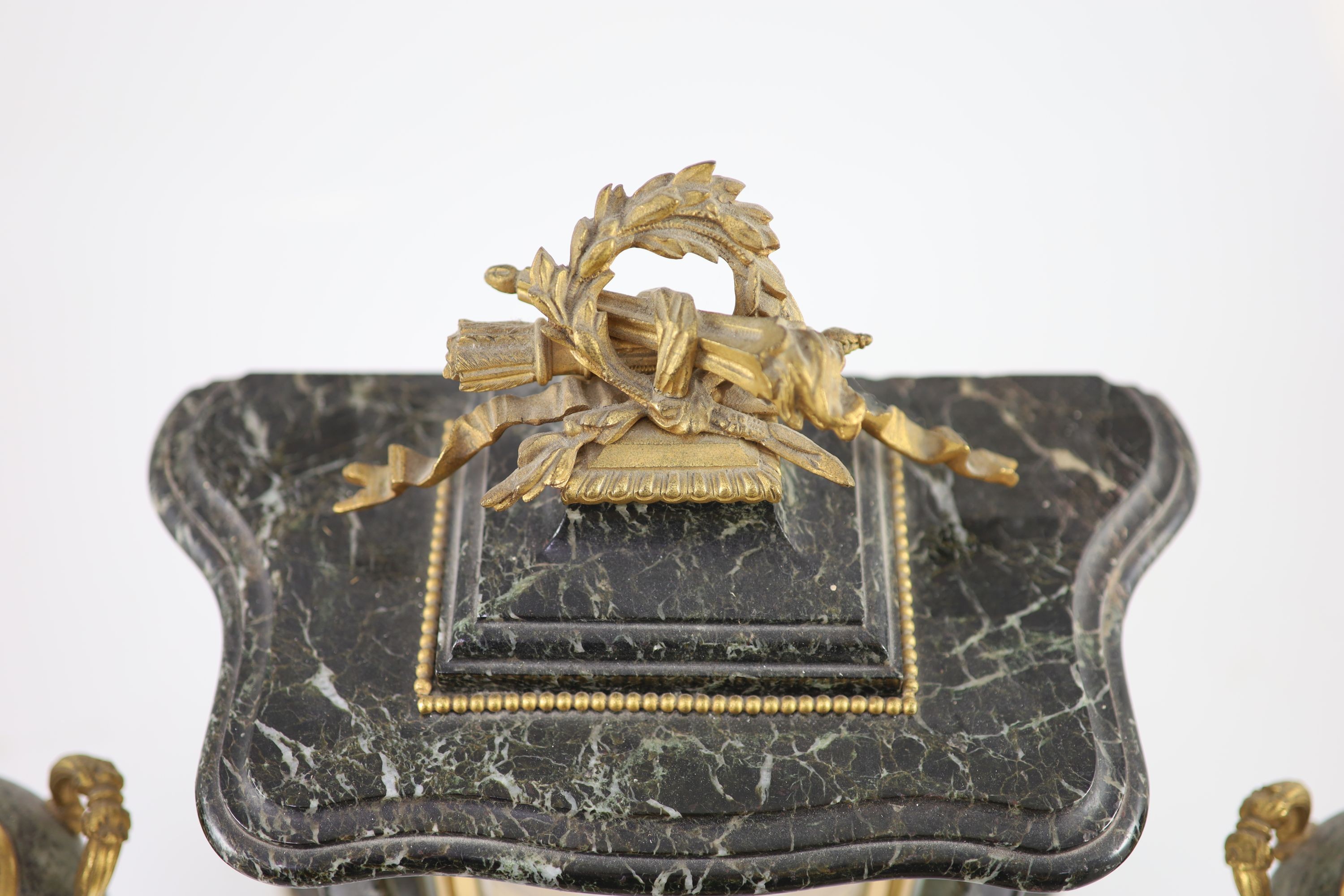 A 19th century French ormolu mounted black variegated three piece clock garniture H 38cm. W 27cm. D 14cm. The urns 31cm high.